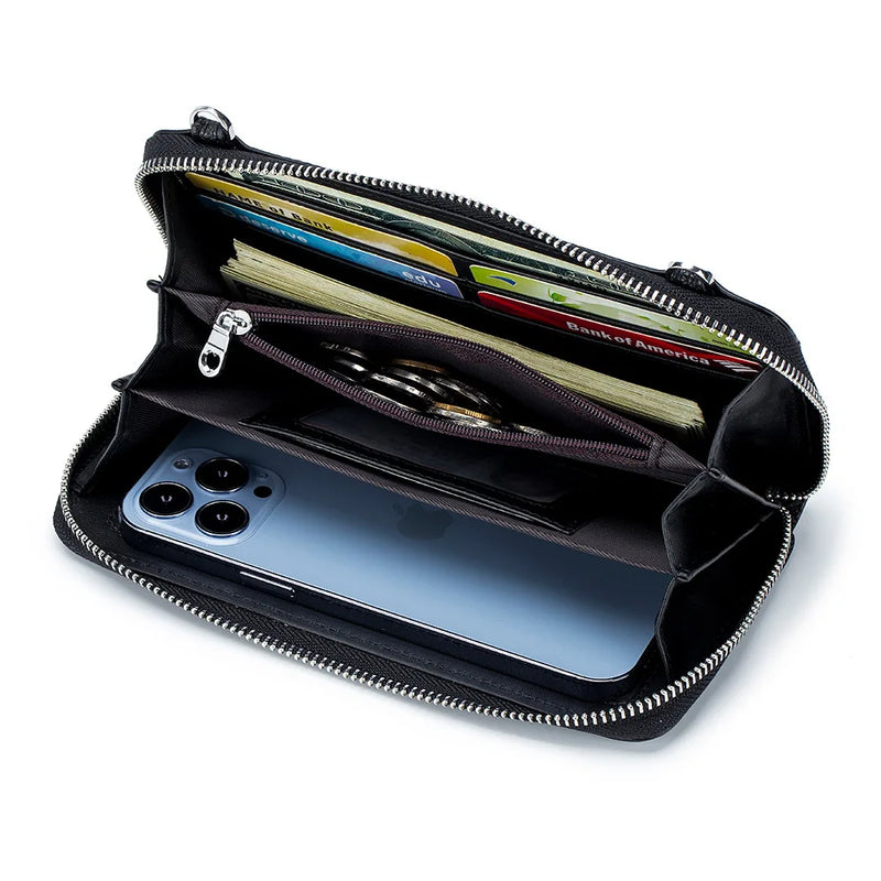 Foto da Bolsa de Ombro para Celular na cor preta aberta, exibindo a organização interna. O celular está guardado em seu compartimento com viseira sensível ao toque, enquanto moedas, dinheiro e cartões estão organizados em seus respectivos slots e bolsos, destacando a praticidade e o design funcional da bolsa